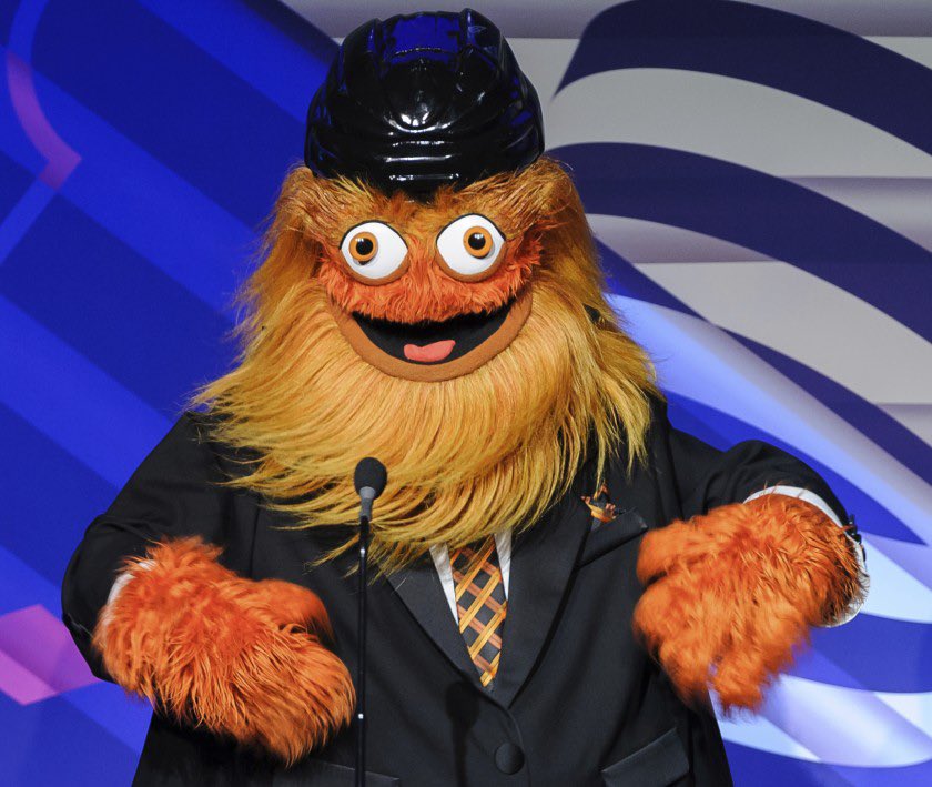 Gritty in a suit in front of a microphone